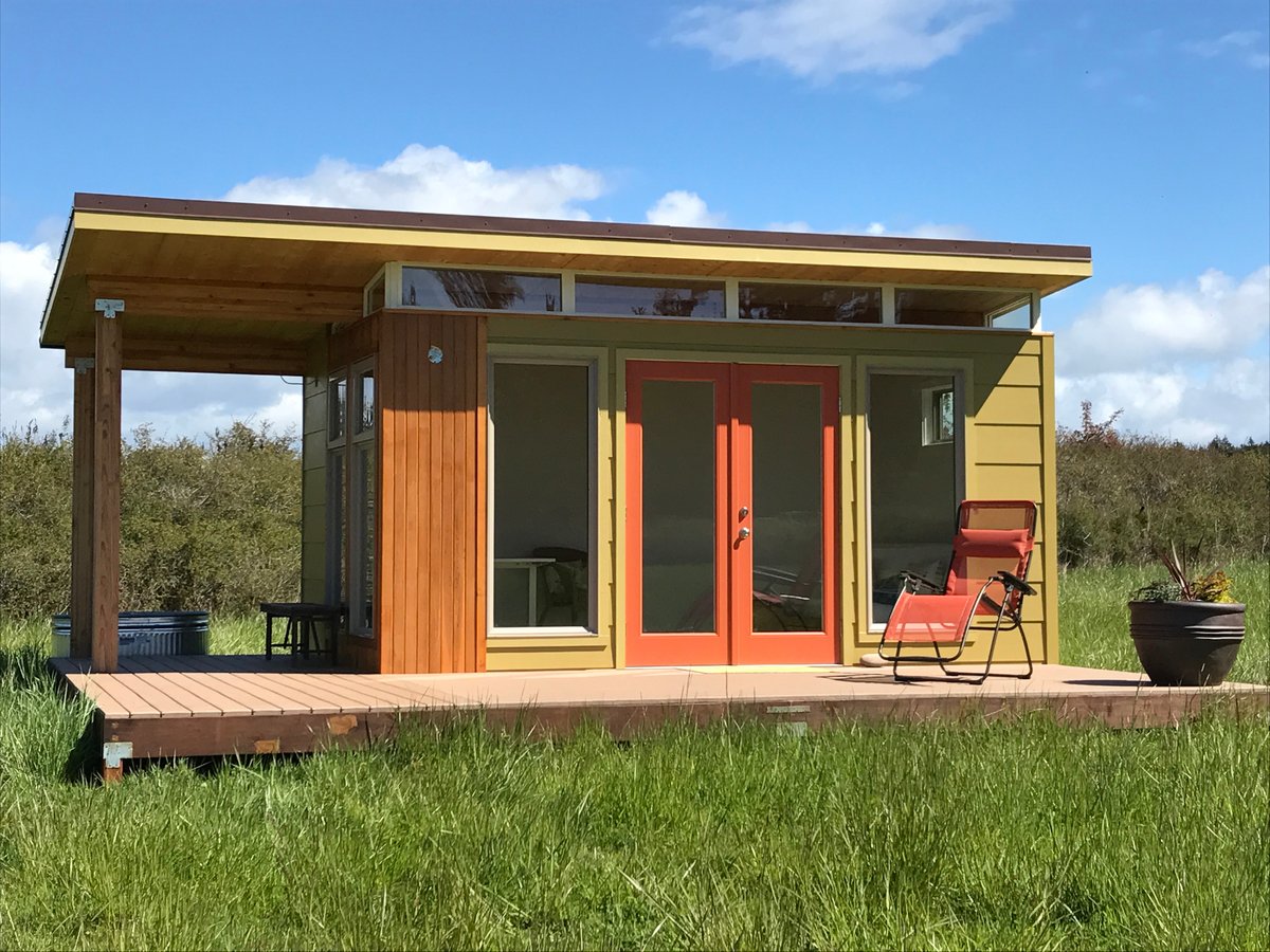 a modern shed studio with a large deck