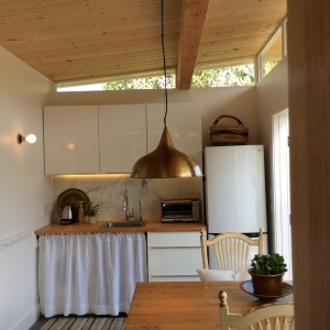 Rebecca selected a smaller refrigerator and a deep sink to create more room in her Modern-Shed guest house's kitchen.